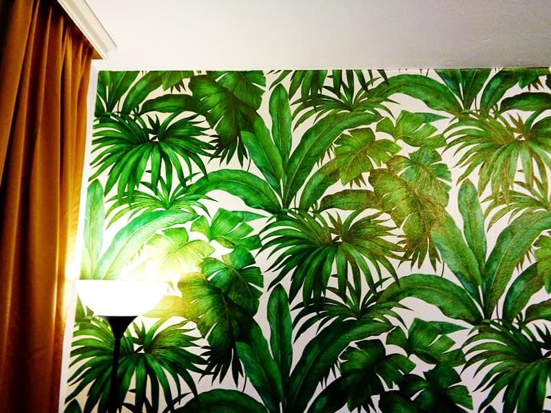 Tapezierte Wand mit einer Mustertapete mit Blättern